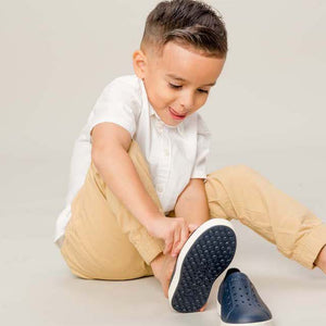 young boy putting on shoes