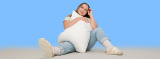 woman hugging pillow on blue background